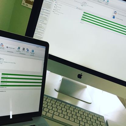 Un iMac e un Macbook su una scrivania, entrambi con memoQ visualizzato sullo schermo